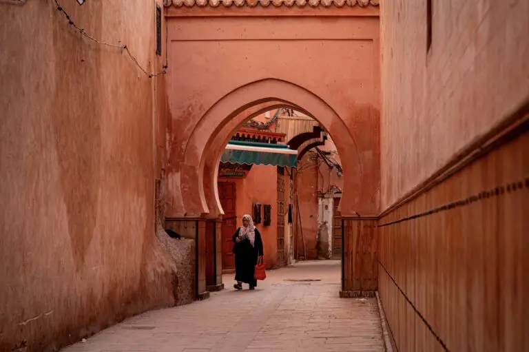 woman walking through arched alleyway in Marrakech medina