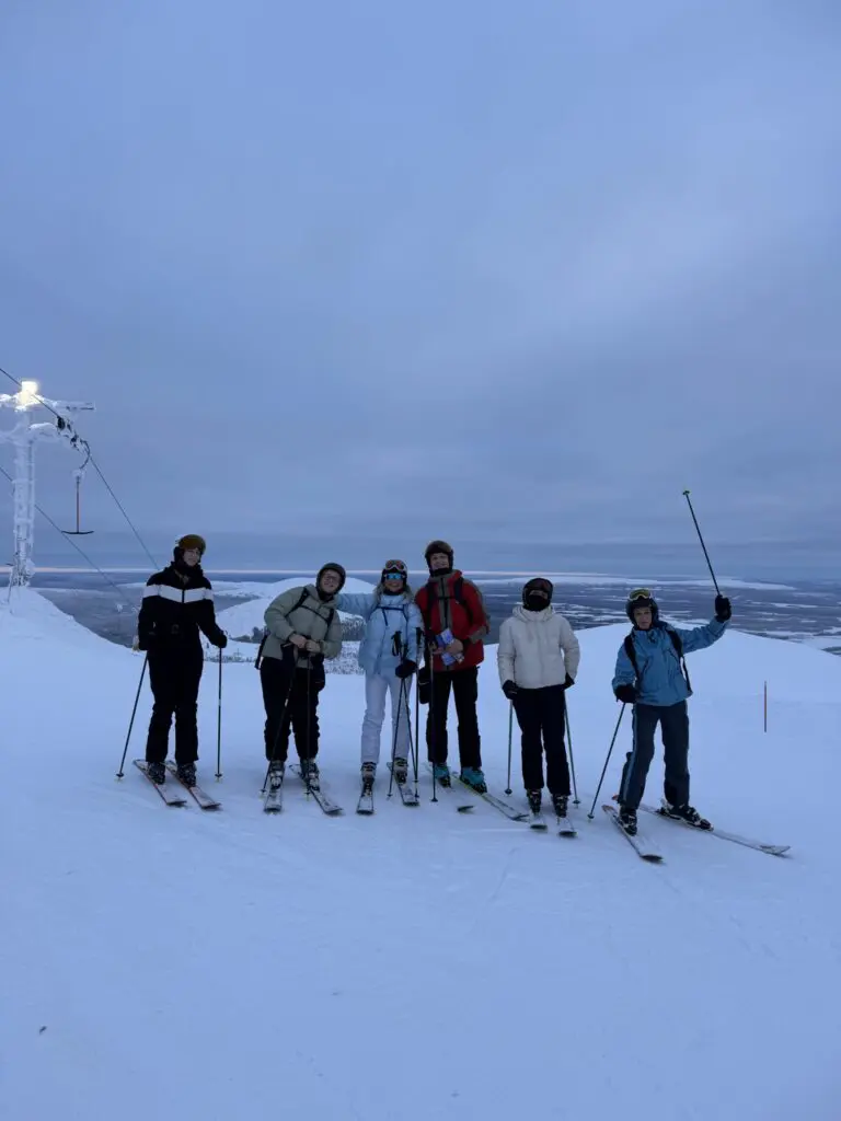 group of friends skiing on a snowy mountain in Lapland