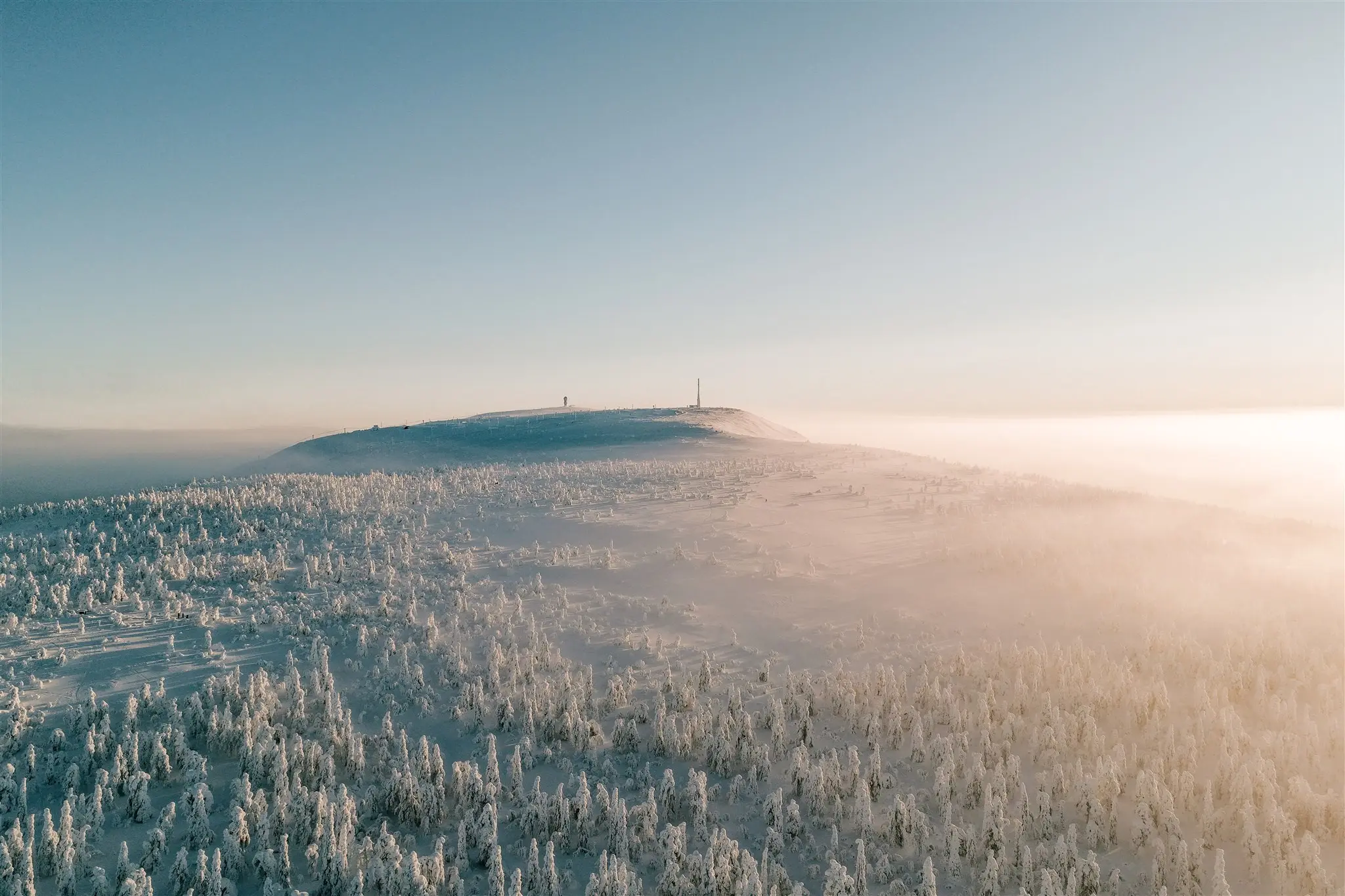 aerial view of snowy Lapland forest and misty mountain at sunrise