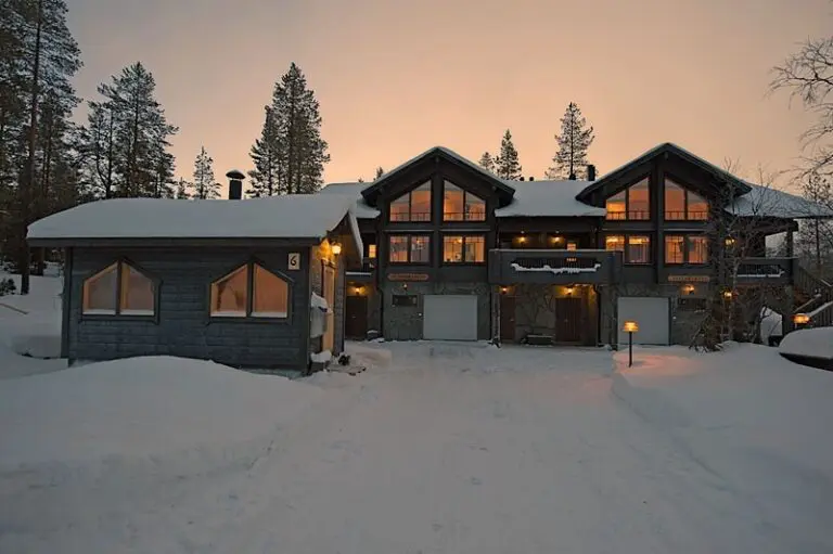 snow-covered accommodation in Lapland at sunset