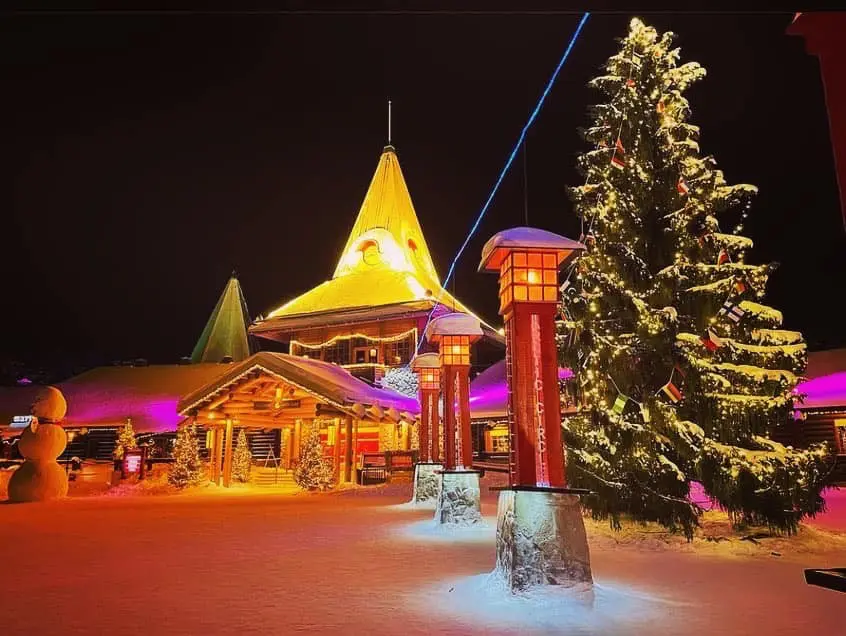 santa claus village at night with christmas tree and snow