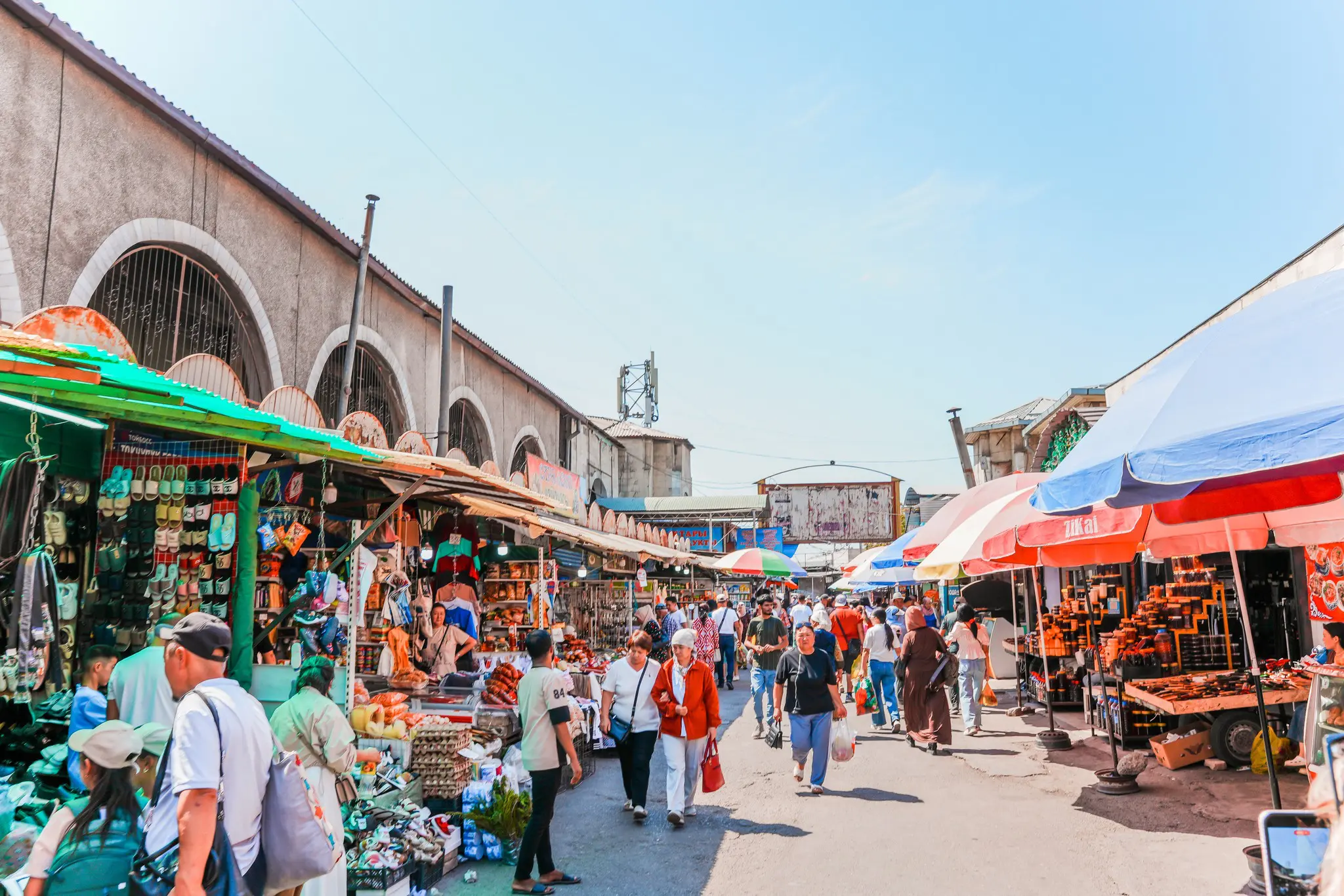 bustling market street with vendors and shoppers under a clear sky