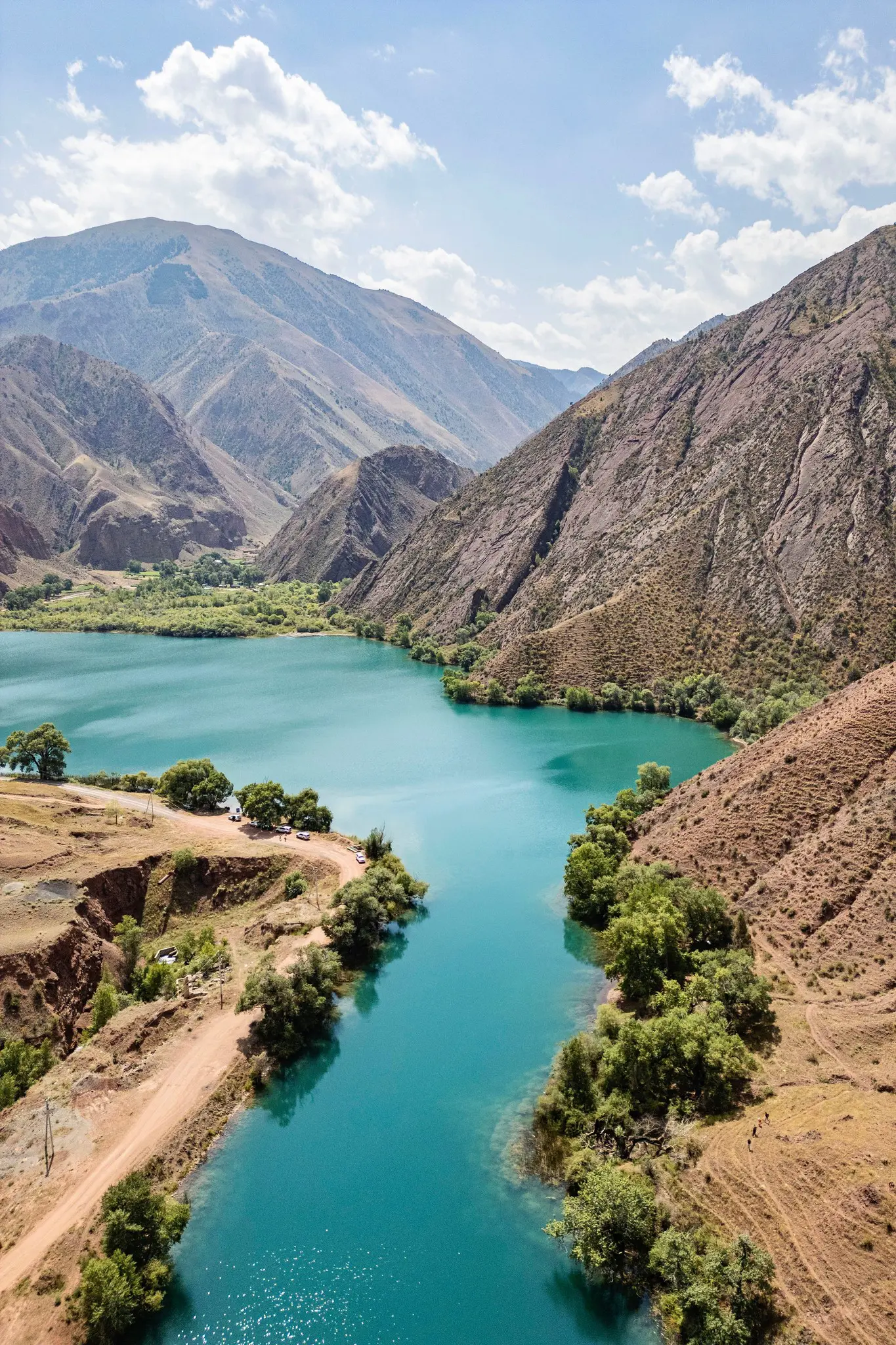 drone shot of turquoise lake in a mountain valley