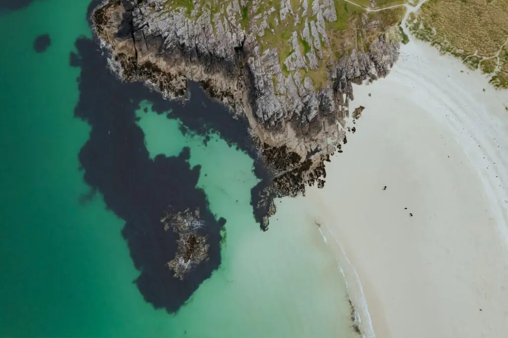 drone shot of a white sand beach and rocky coastline in Scotland