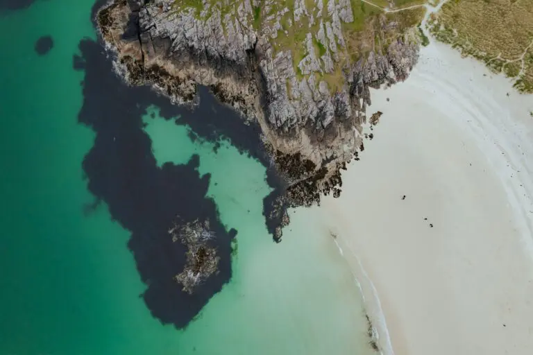 drone shot of a white sand beach and rocky coastline in Scotland