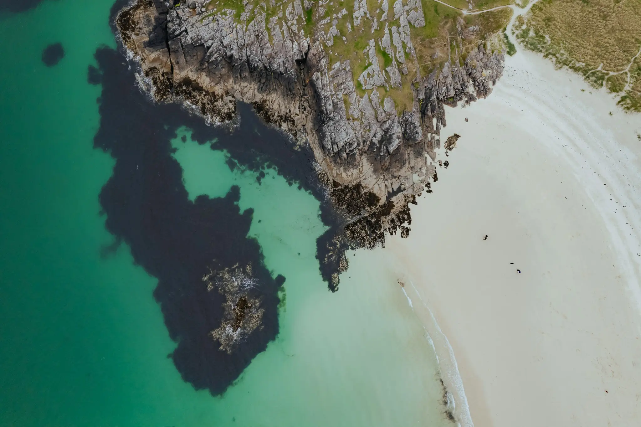 drone shot of a white sand beach and rocky coastline in Scotland