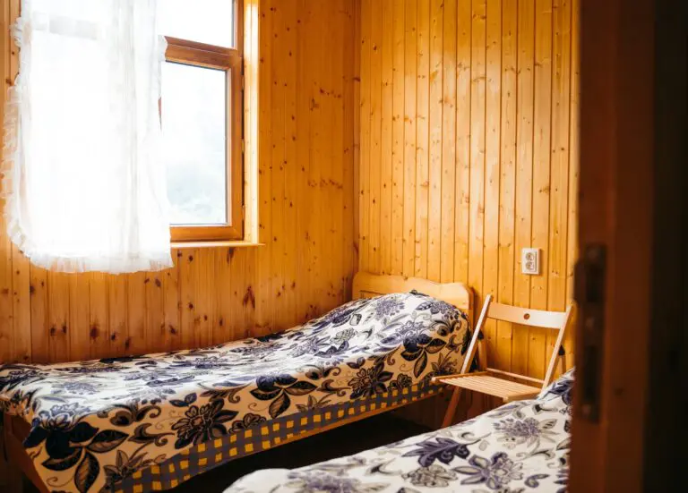 cozy twin bedroom with wooden walls and floral bedspreads