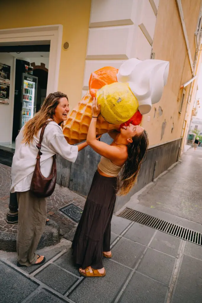 two women laughing with giant ice cream cone on Amalfi street
