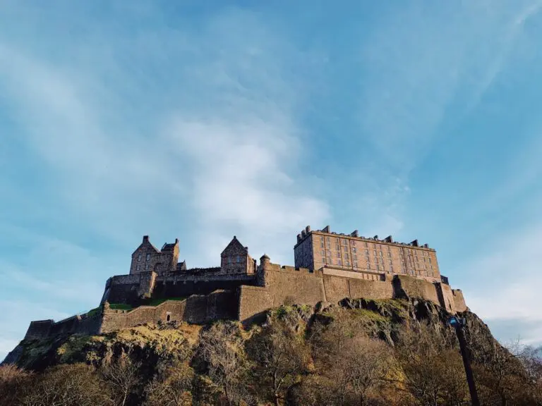 edinburgh castle on a hill under a blue sky