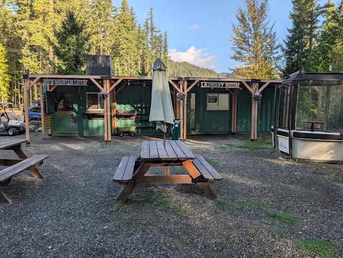 outdoor eating area with picnic tables and green buildings