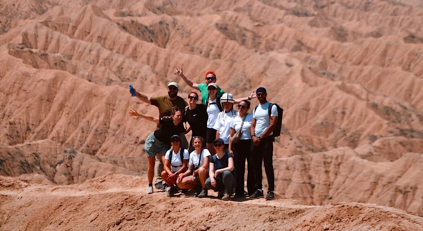 group of hikers posing on a desert mountain ridge